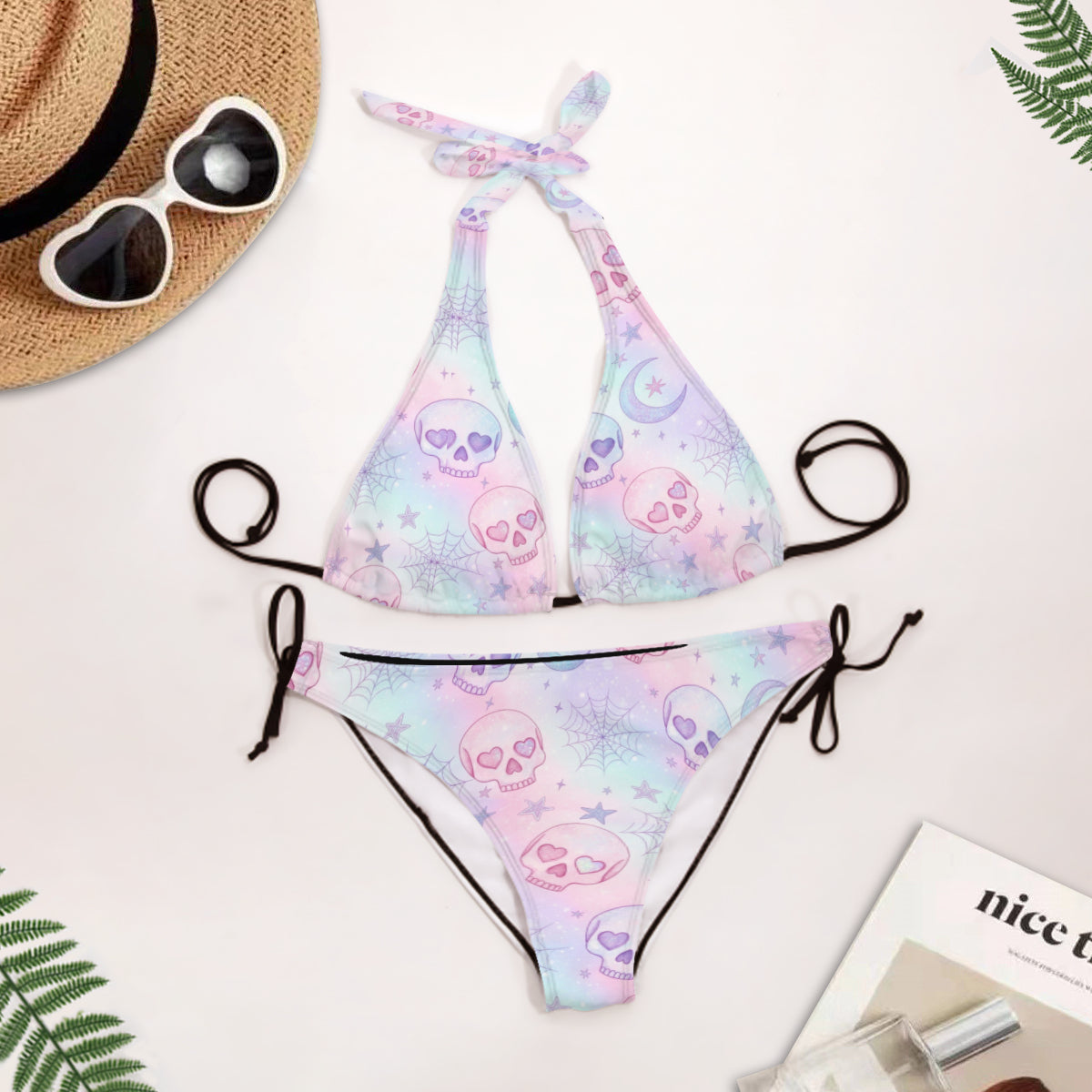 Pastel skull pattern bikini set with sunglasses and a hat on a light background