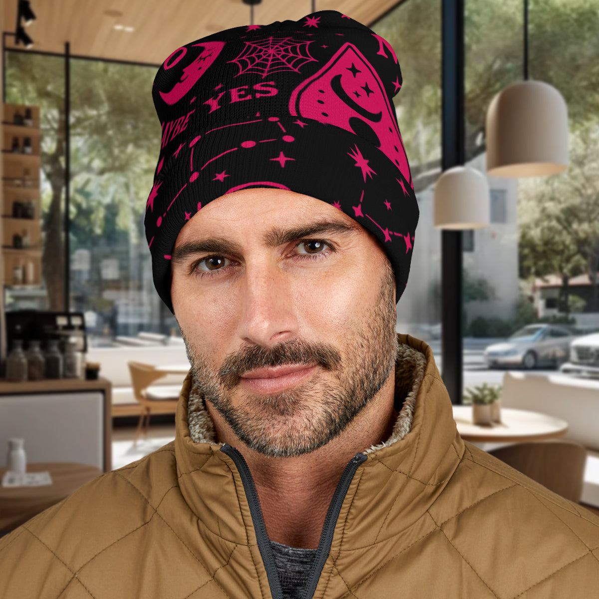 Man wearing a black and hot pink Ouija Board patterned Beanie