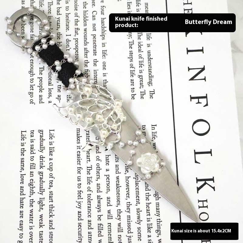 Decorative Athame with butterfly design and pearls on a newspaper background